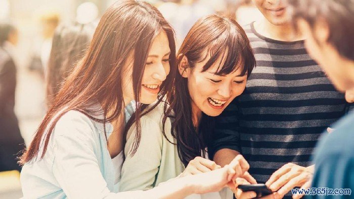 Closeup of thoughtful young Asian woman holding mobile phone and surfing Internet. Attractive student taking selfie at cafe. Communication and work balance concept